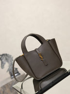 YSL dark structured tote-style bag with top handle, gold-tone YSL logo, and strap