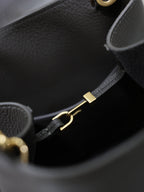 YSL dark bag interior with gold-tone clasp hardware and black strap adjuster