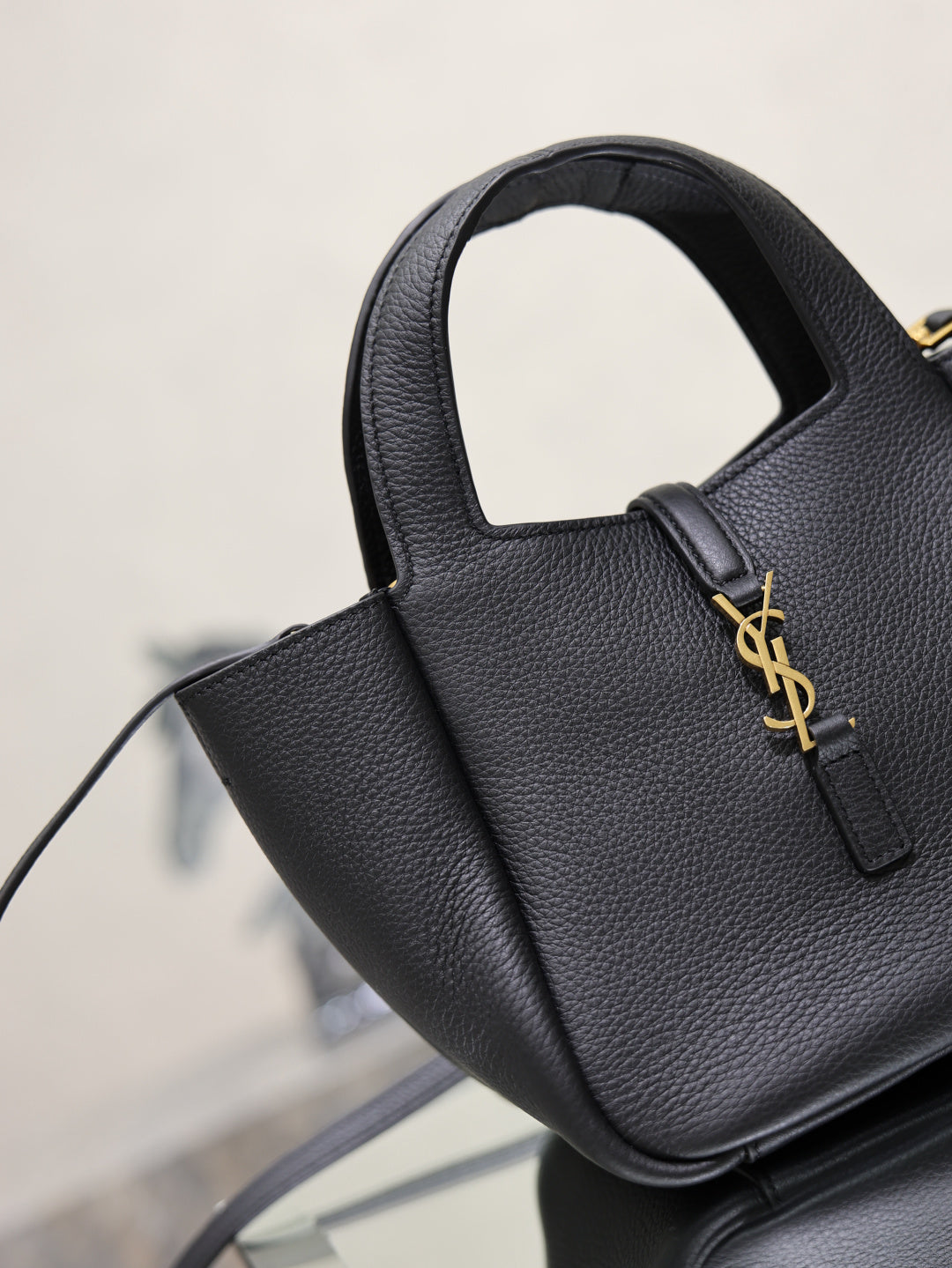 YSL black leather mini tote bag close-up with top handle and gold logo detail