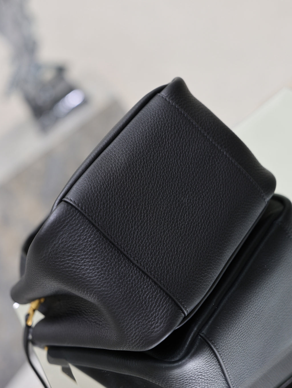 YSL black leather mini tote bag corner close-up with stitched seam and paneling