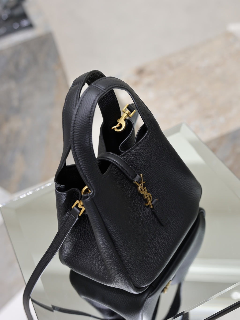 YSL black leather mini tote bag angled view with gold logo on front panel