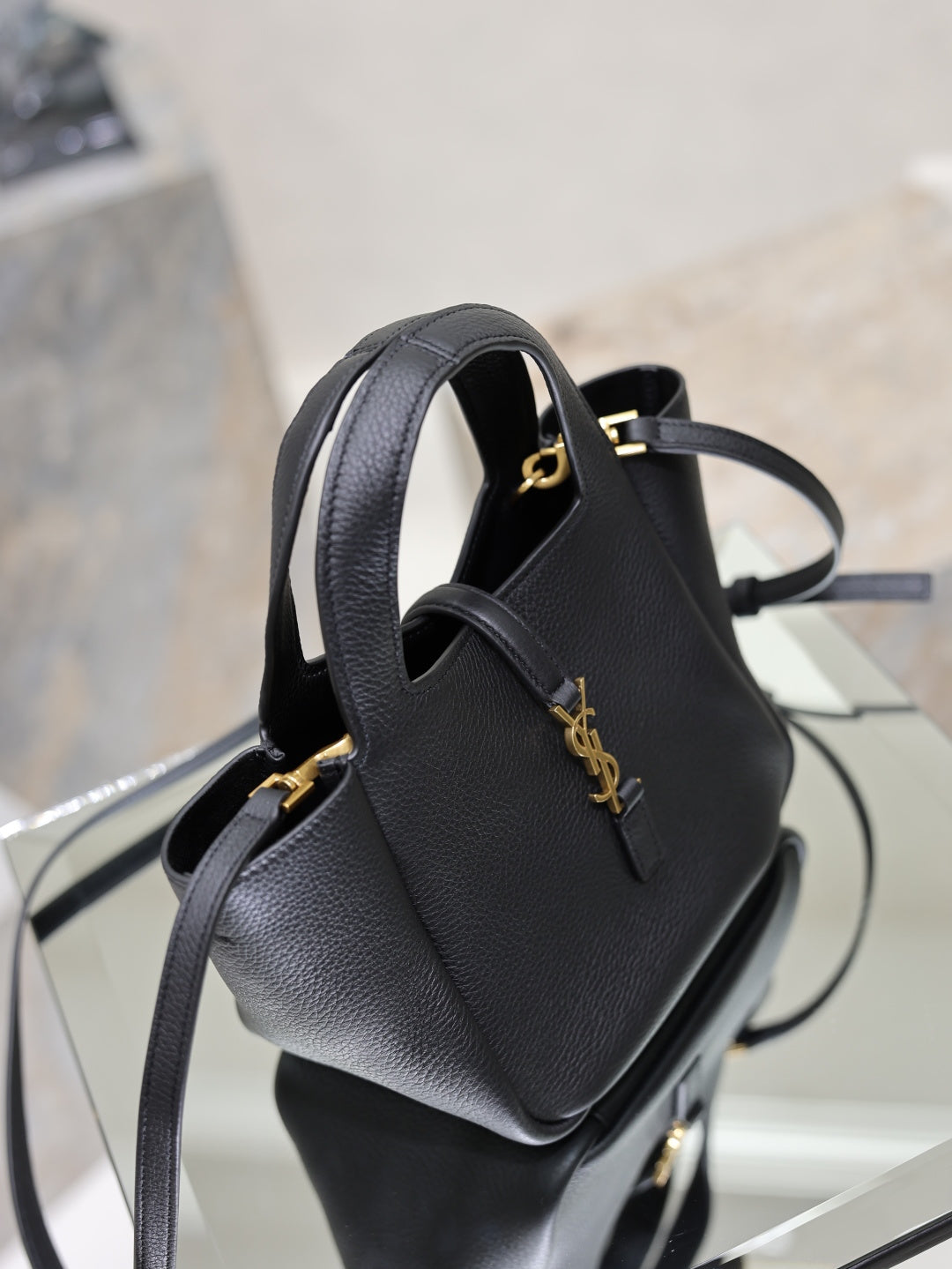 YSL black leather mini tote bag side view with gold logo accent and strap