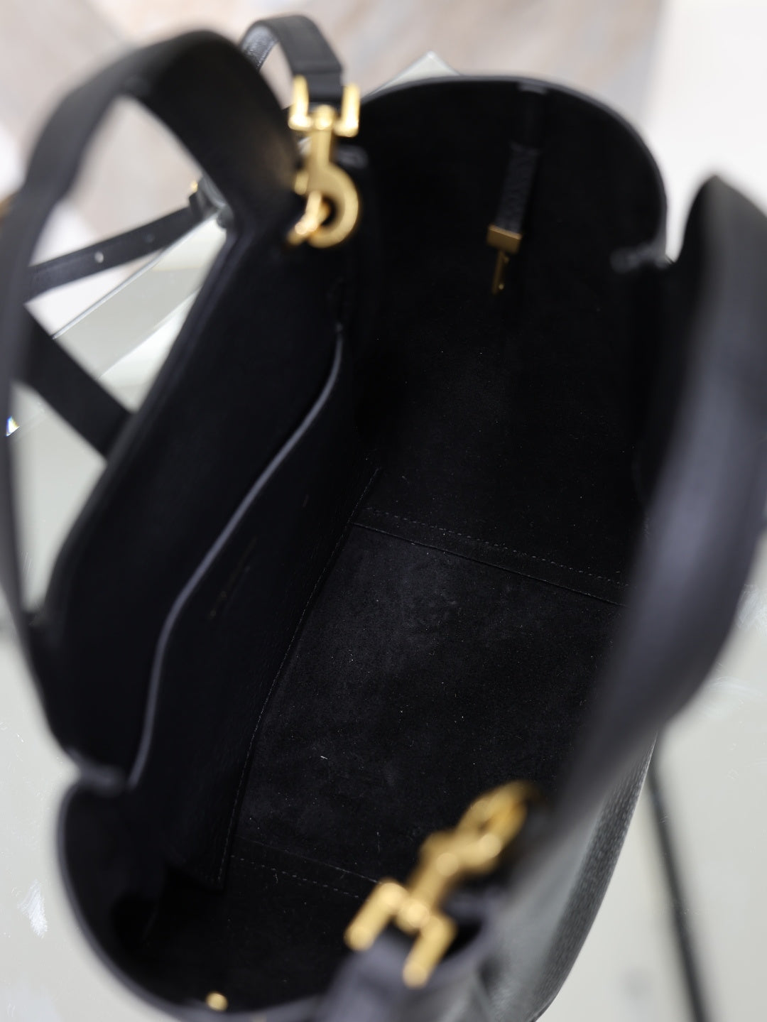 YSL black leather mini tote bag interior view with gold top hardware and logo charm