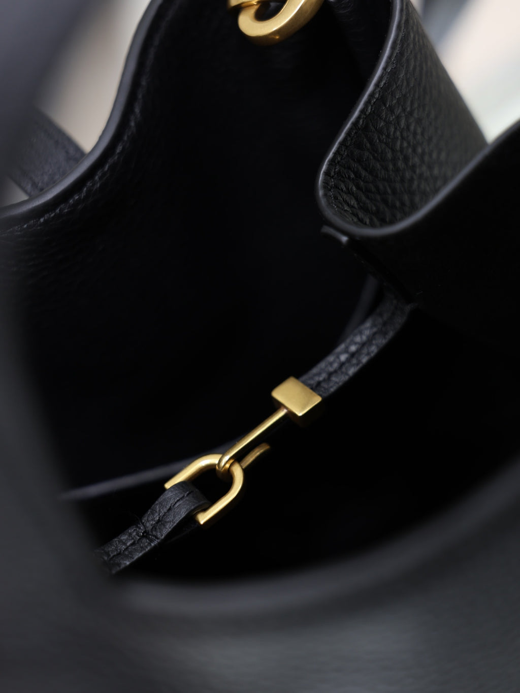 YSL black leather mini tote bag close-up of gold hardware strap and zipper pull