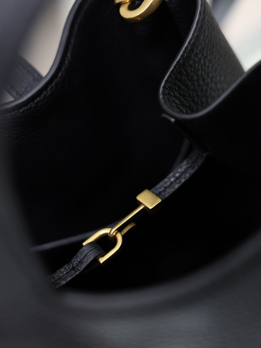 YSL black leather mini tote bag close-up of gold hardware strap and zipper pull