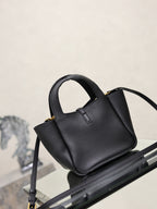 YSL black leather mini tote bag angled view with shoulder strap and gold logo plaque