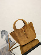 Tan suede mini tote bag with YSL logo charm and shoulder strap, angled view.