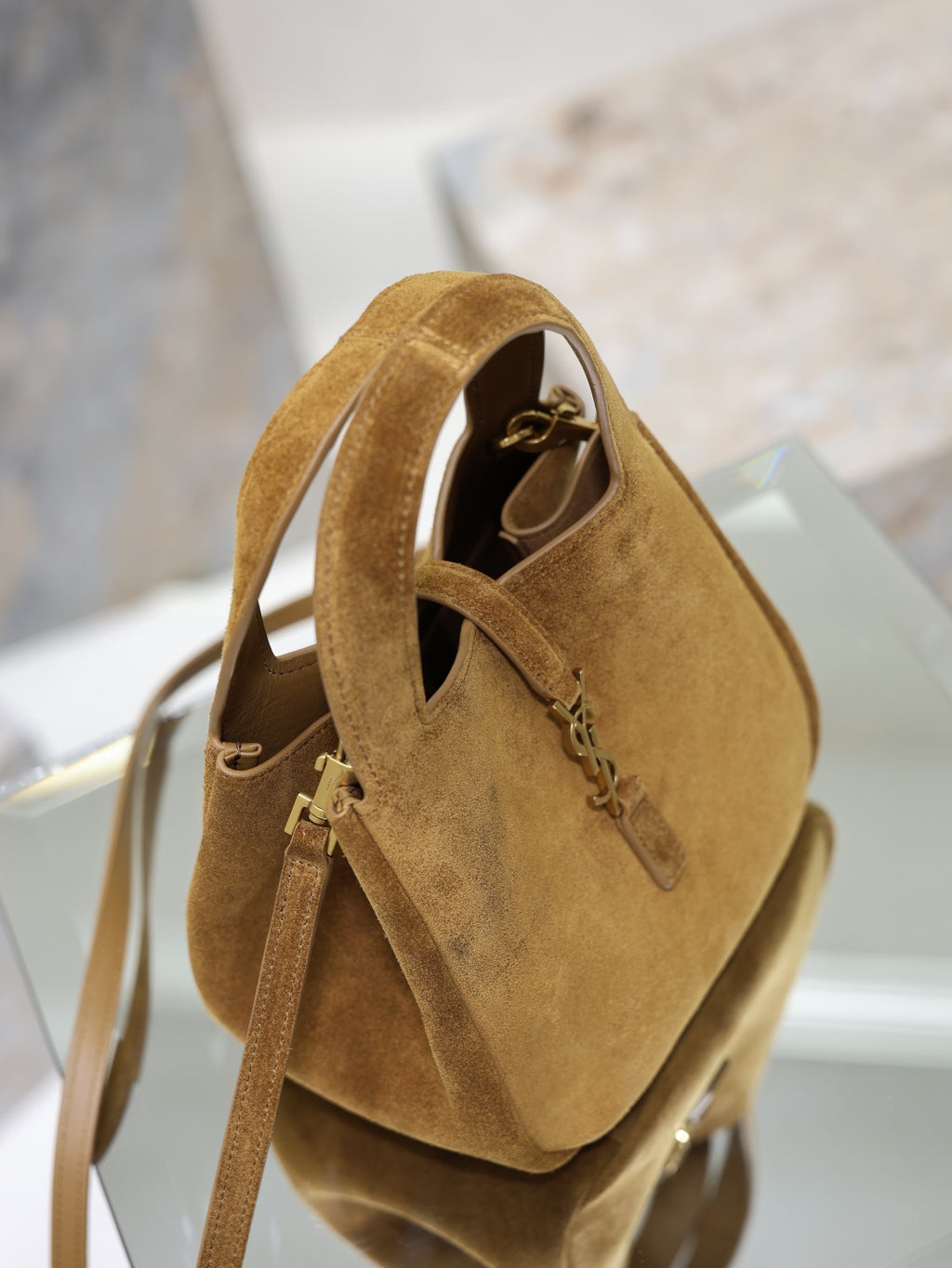 Tan suede mini tote bag side view with top handles and shoulder strap.