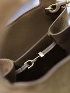 Tan suede mini tote interior with zipper pocket and gold-tone hardware.