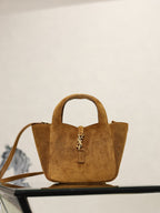 Tan suede mini tote with YSL logo charm, two handles, and shoulder strap.