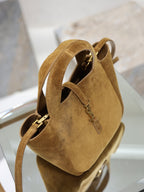 Tan suede mini tote with open top, gold hardware, two handles, and strap.