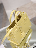 YSL mini handbag with top handles, glossy yellow, side view with gold-tone hardware