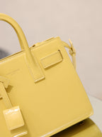 YSL mini handbag with top handles, glossy yellow, close-up of front flap and buckle