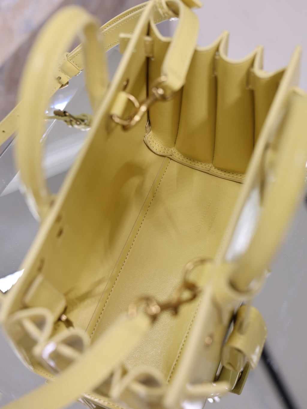 YSL mini handbag interior view, glossy yellow, accordion compartments and metal clasps