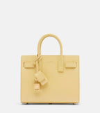 Light yellow structured leather tote bag with top handles and front flap pockets