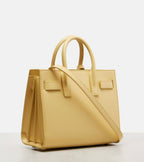 Light yellow structured leather tote bag with adjustable crossbody strap