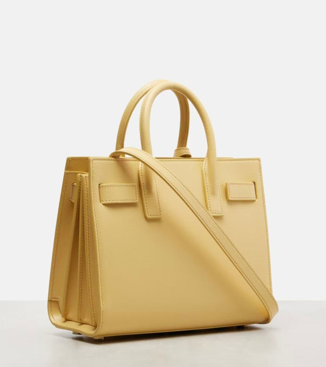 Light yellow structured leather tote bag with adjustable crossbody strap