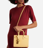 Light yellow structured tote bag with long shoulder strap on a model