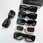 Chanel cat-eye glasses assortment with black, white, and green frames and gold CC logos.