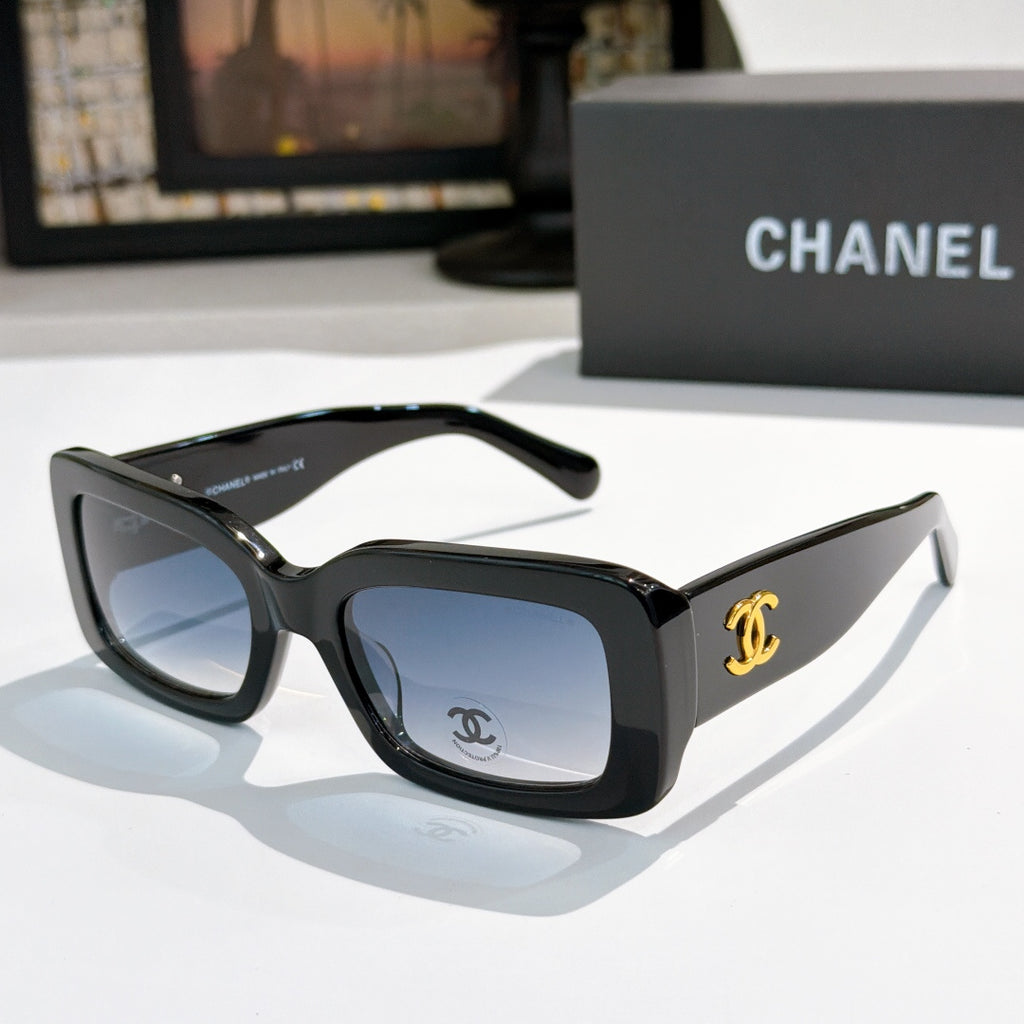 Chanel cat-eye glasses with black frames, tinted lenses, and gold CC logo detail.