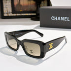 Chanel cat-eye glasses with black frames and gold CC logo at the temple.