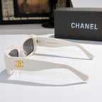 Chanel cat-eye glasses with white frames and gold CC logo on the temple.