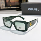 Chanel cat-eye glasses with dark green frames and gold CC logo at the temple.