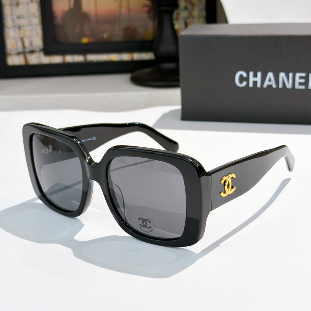 Black oversized square sunglasses with gold CC logo on temple.