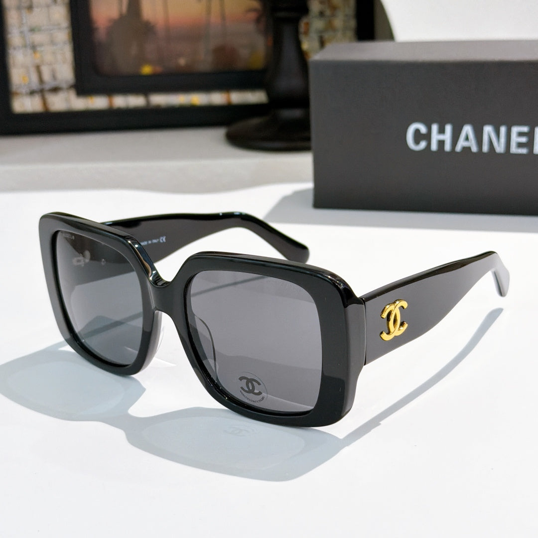 Black oversized square sunglasses with gold CC logo on temple.