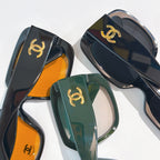 Stacked square sunglasses with gold CC logos in orange, smoke, and green tones.