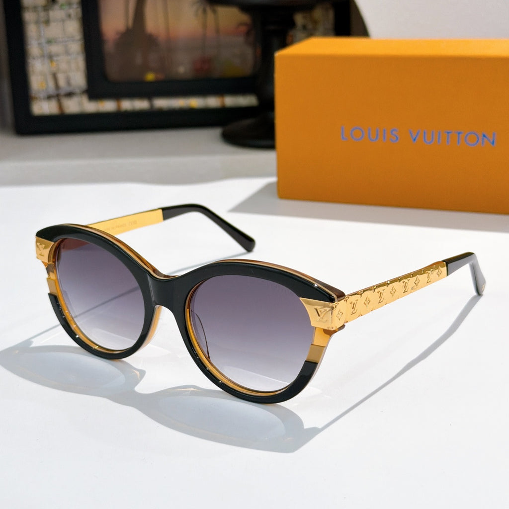 Round black sunglasses with dark purple-tinted lenses and gold logo temple arms
