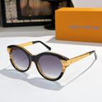 Round black sunglasses with dark purple-tinted lenses and gold logo temple arms