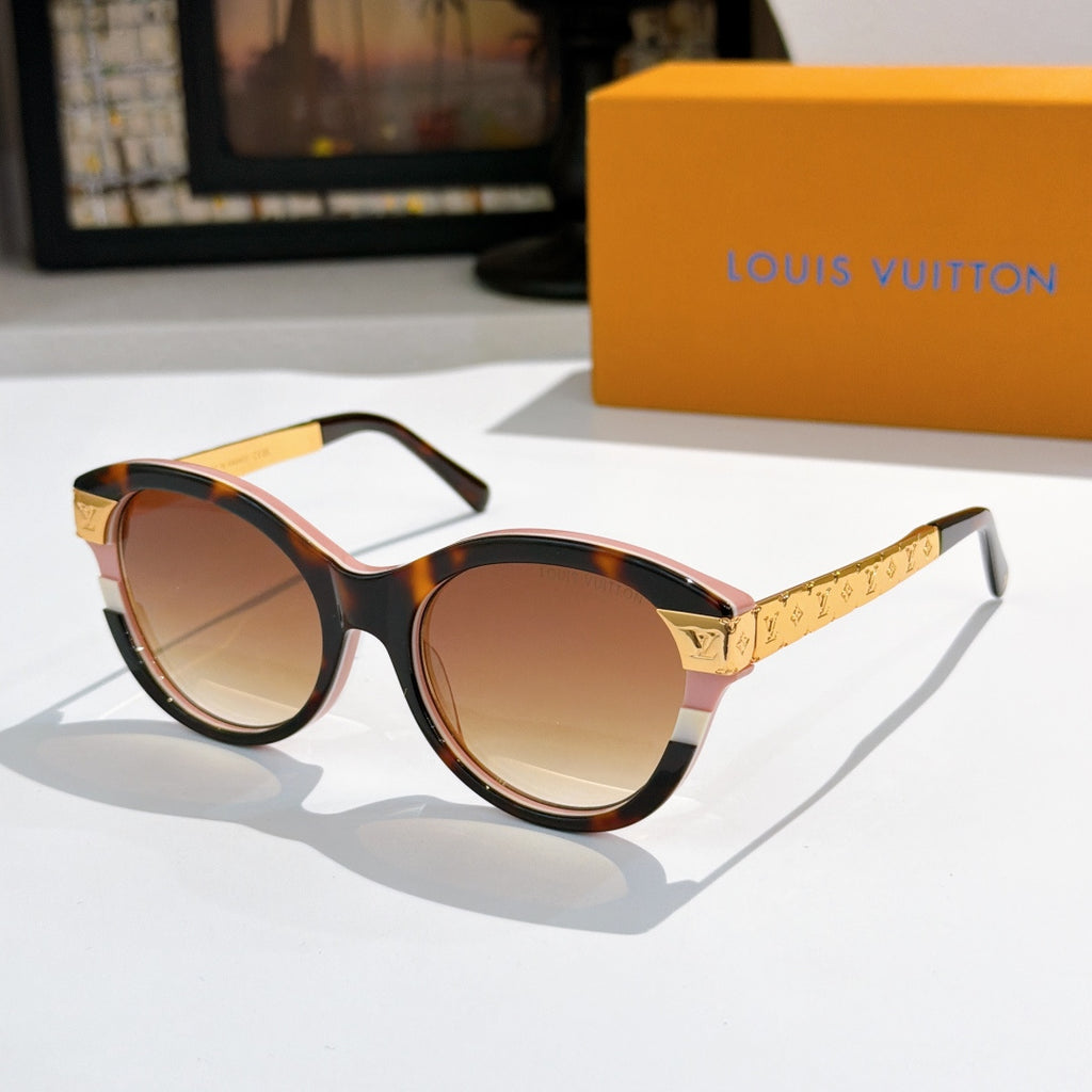 Round burgundy sunglasses with warm brown-tinted lenses and gold logo temple arms
