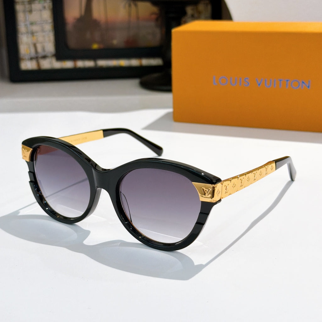 Round black sunglasses with dark purple-tinted lenses and gold logo temple arms