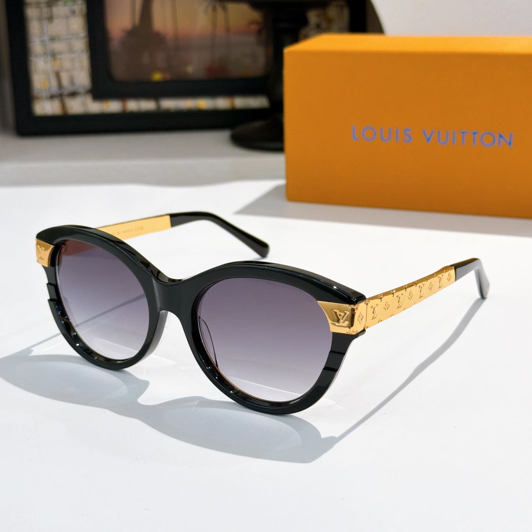 Round black sunglasses with dark purple-tinted lenses and gold logo temple arms