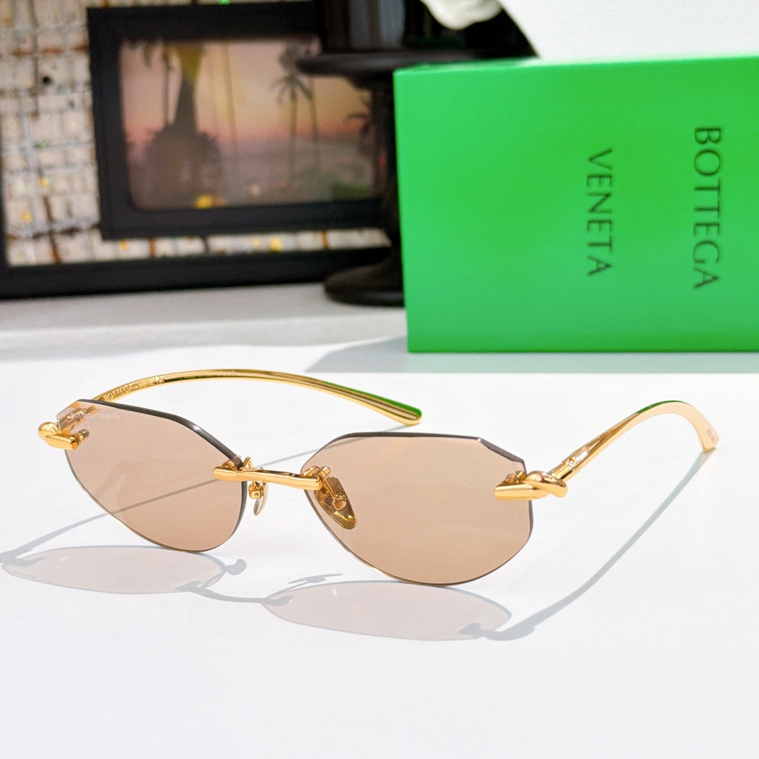 Gold-tone sunglasses with light brown tinted lenses and metallic hinge details.