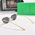 Gold-tone sunglasses with black-tinted lenses and long curved metal temples.