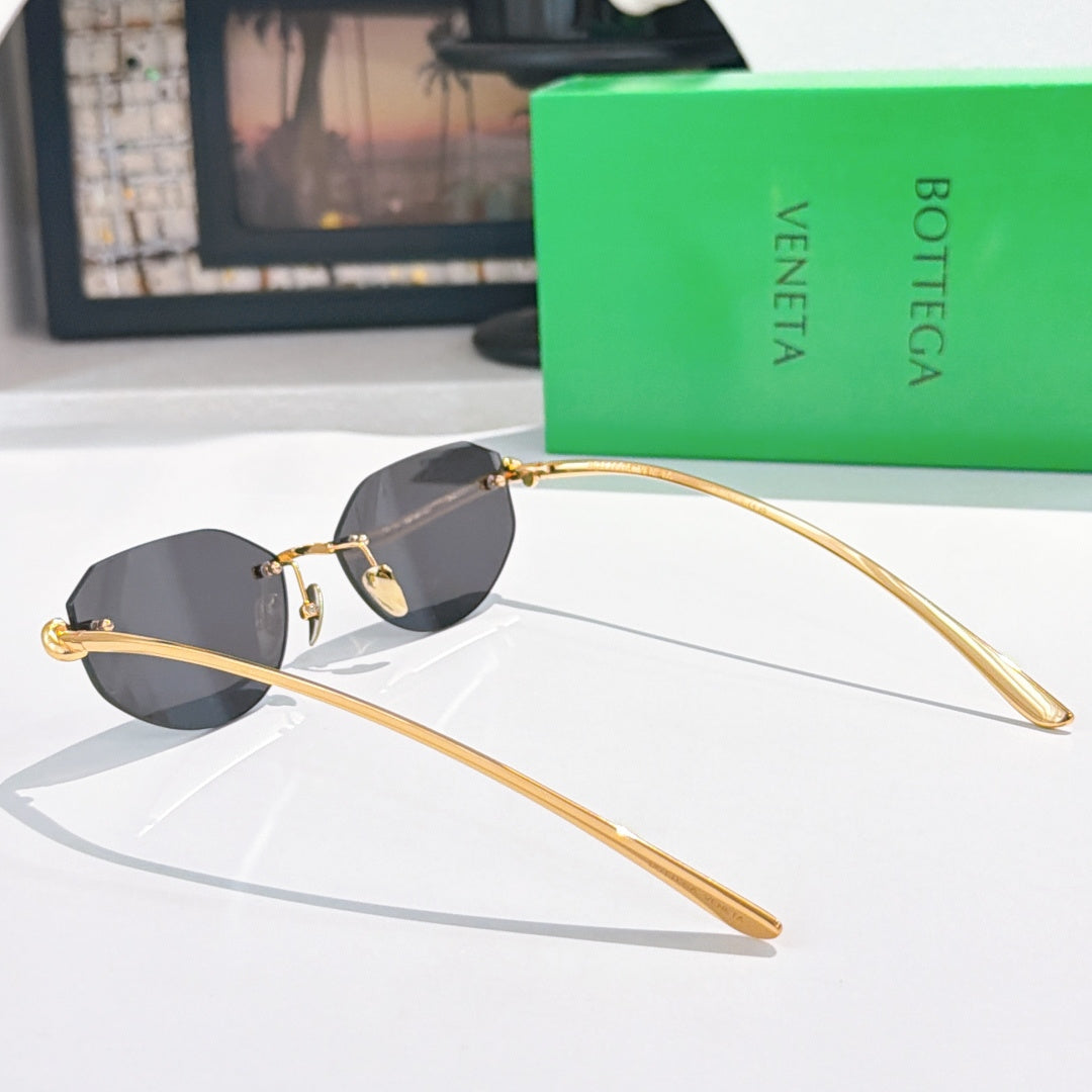 Gold-tone sunglasses with black-tinted lenses and long curved metal temples.