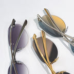 Pair of metal sunglasses with tinted lenses in gold and dark frames.