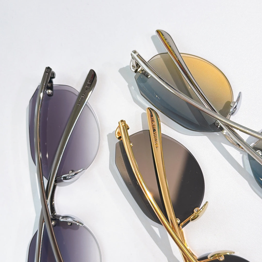 Pair of metal sunglasses with tinted lenses in gold and dark frames.