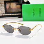 Gold-tone sunglasses with dark gray-tinted lenses and slim metal arms.