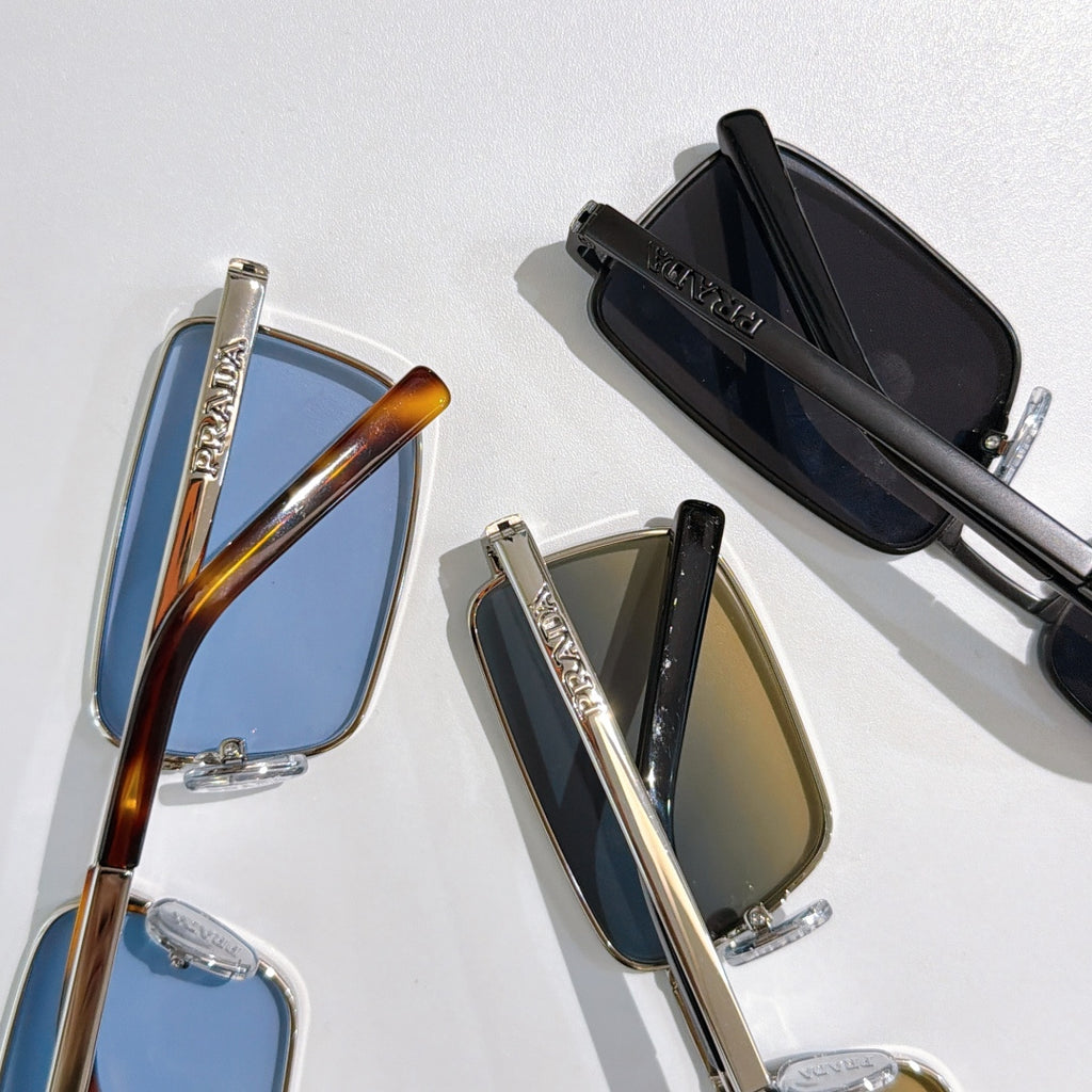 Prada sunglasses close-up showing multiple frames with tinted lenses in blue, black, and tan