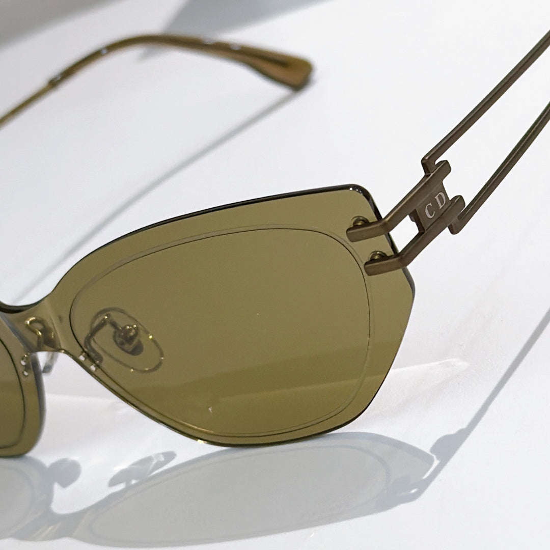 Dior cat-eye sunglasses close-up with olive lenses and metal temple detail