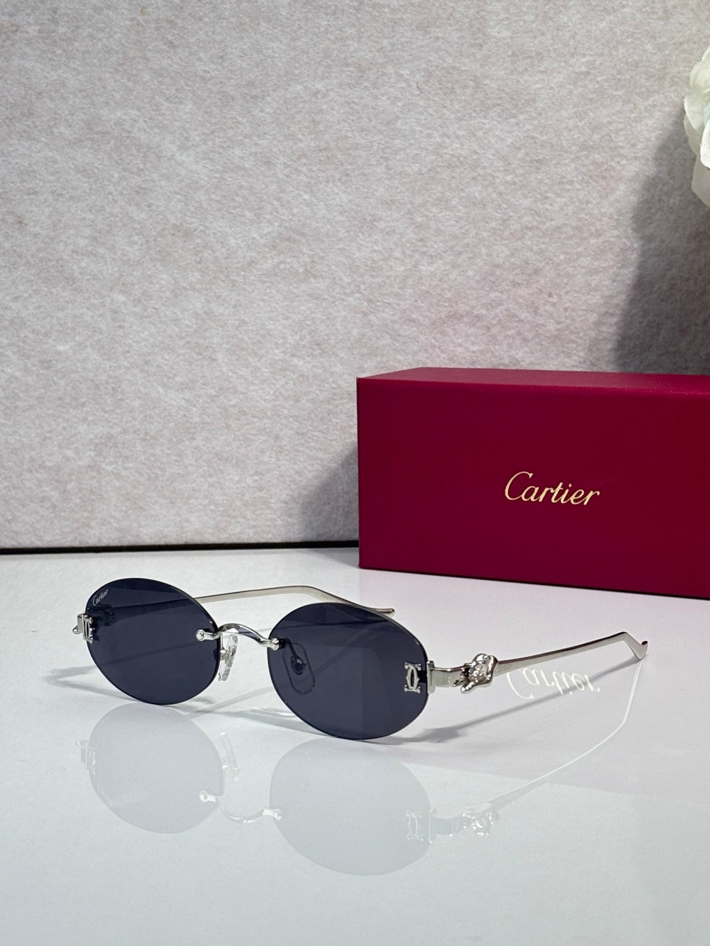 Round dark blue-tinted sunglasses with gold-tone metal frames and ornate hinge detail