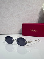 Round dark blue-tinted sunglasses with gold-tone metal frames and ornate hinge detail