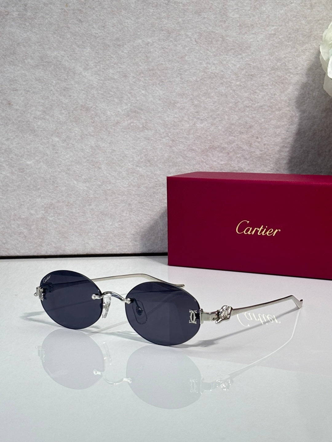 Round dark blue-tinted sunglasses with gold-tone metal frames and ornate hinge detail