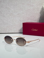 Round brown-tinted sunglasses with gold-tone metal frames and decorative hinge detail