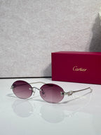 Round mauve-tinted sunglasses with gold-tone metal frames and curved top bar