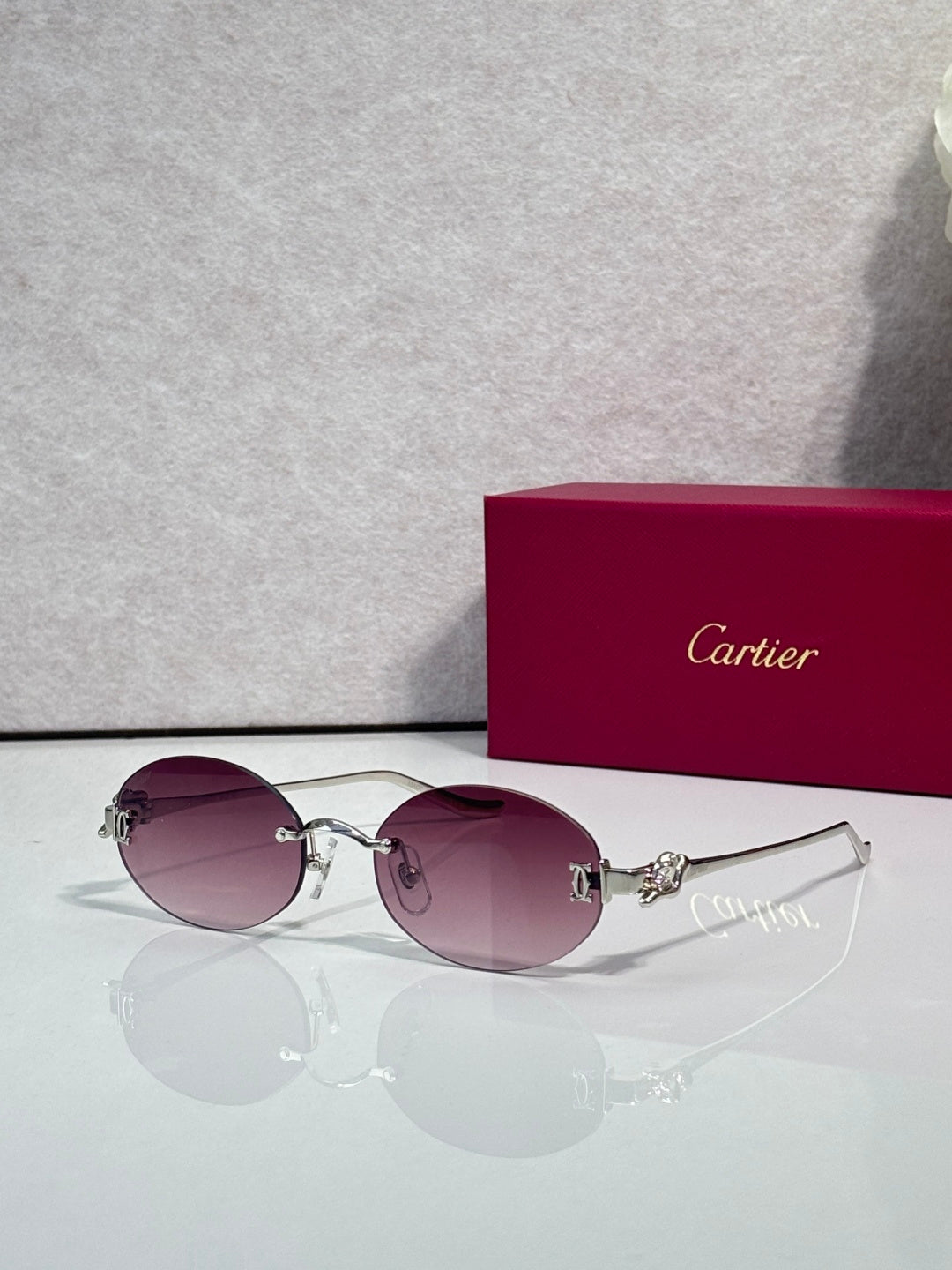 Round mauve-tinted sunglasses with gold-tone metal frames and curved top bar