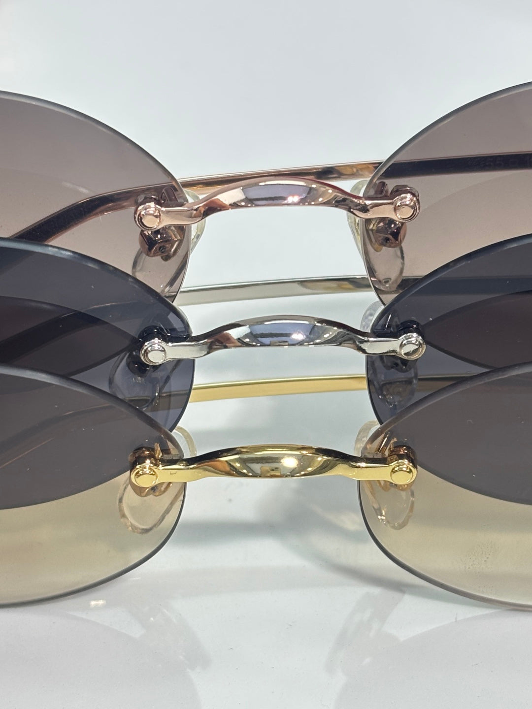 Round dark-tinted sunglasses with gold-tone bridge and ornate frame hinges